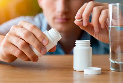Мужчина пьет таблетки